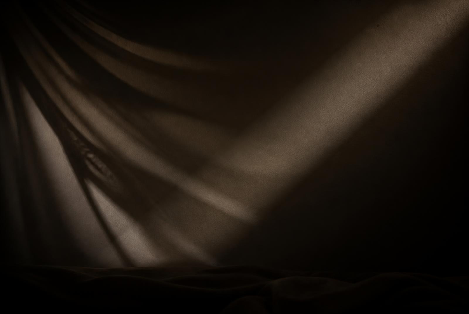 Abstrakte Licht- und Schattenstudie auf Stoff im dunklen Studio