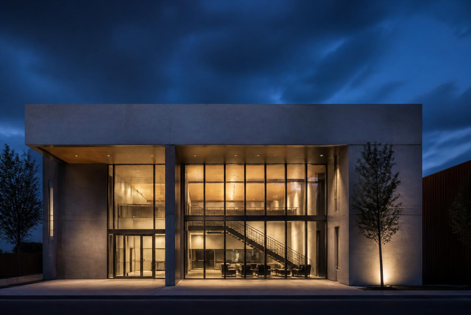 Moderne Gebäudefassade aus Beton und Glas zur blauen Stunde